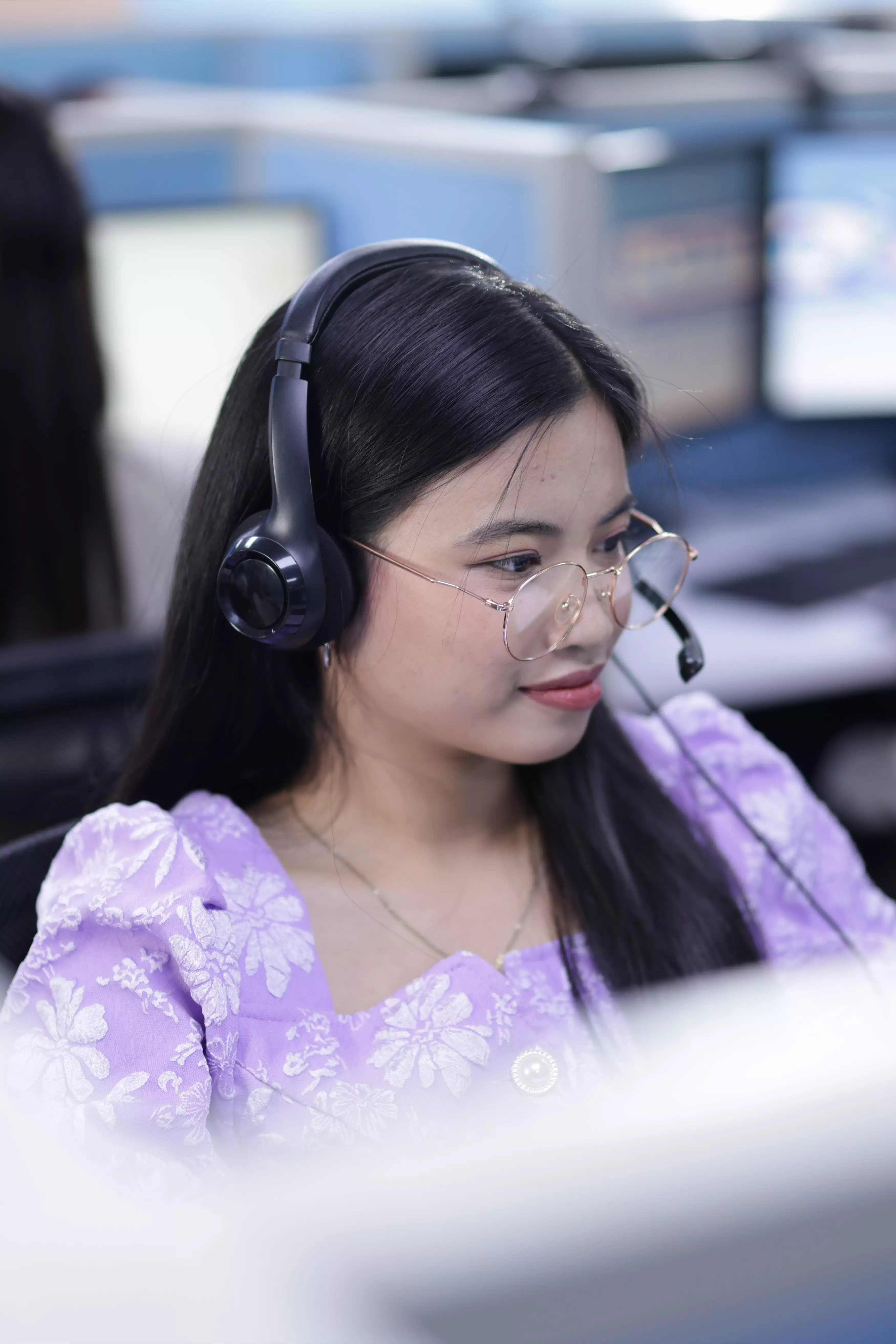 Female agent focused and working at a computer workstation.