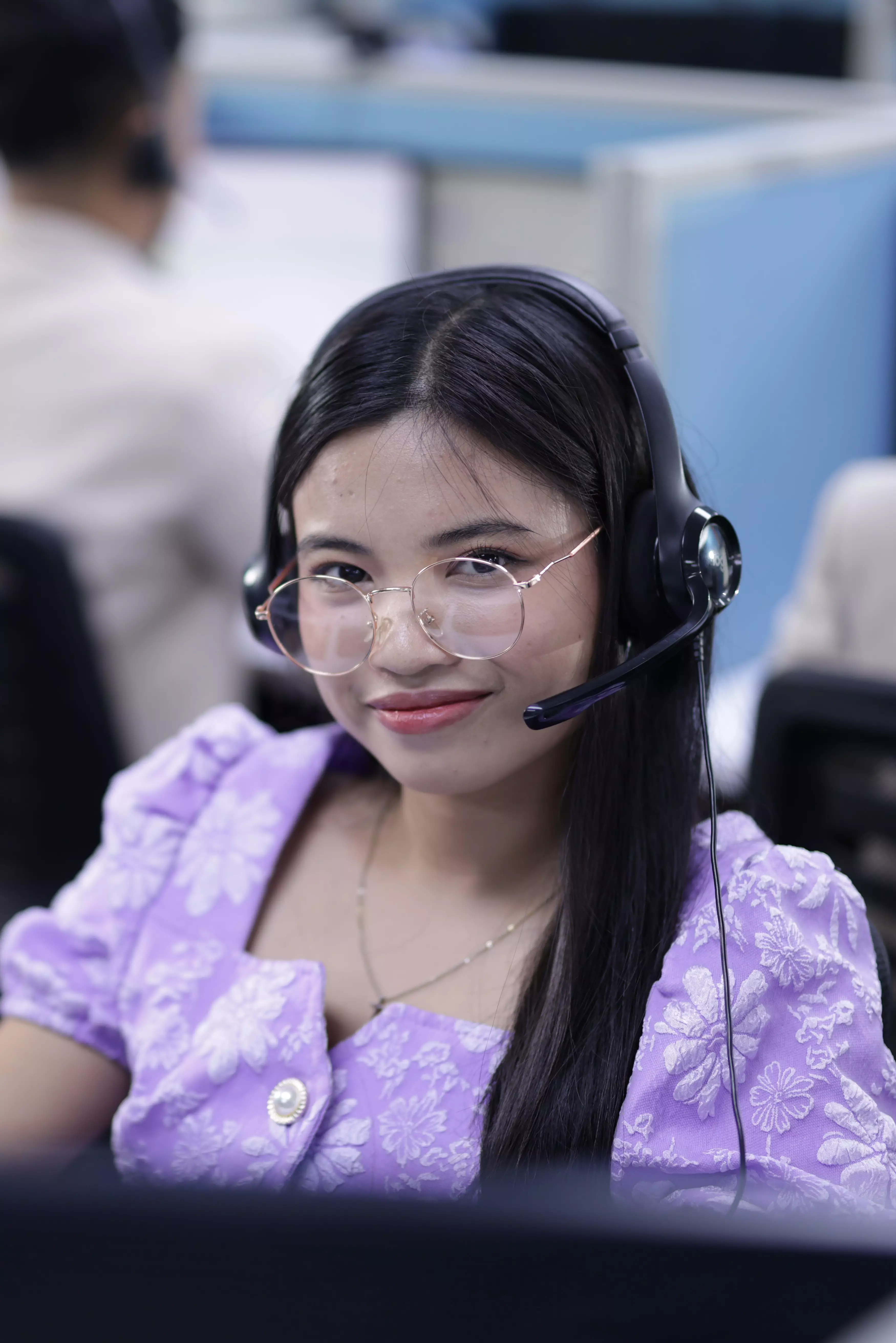Female agent looking at the camera while working in a professional office setting.