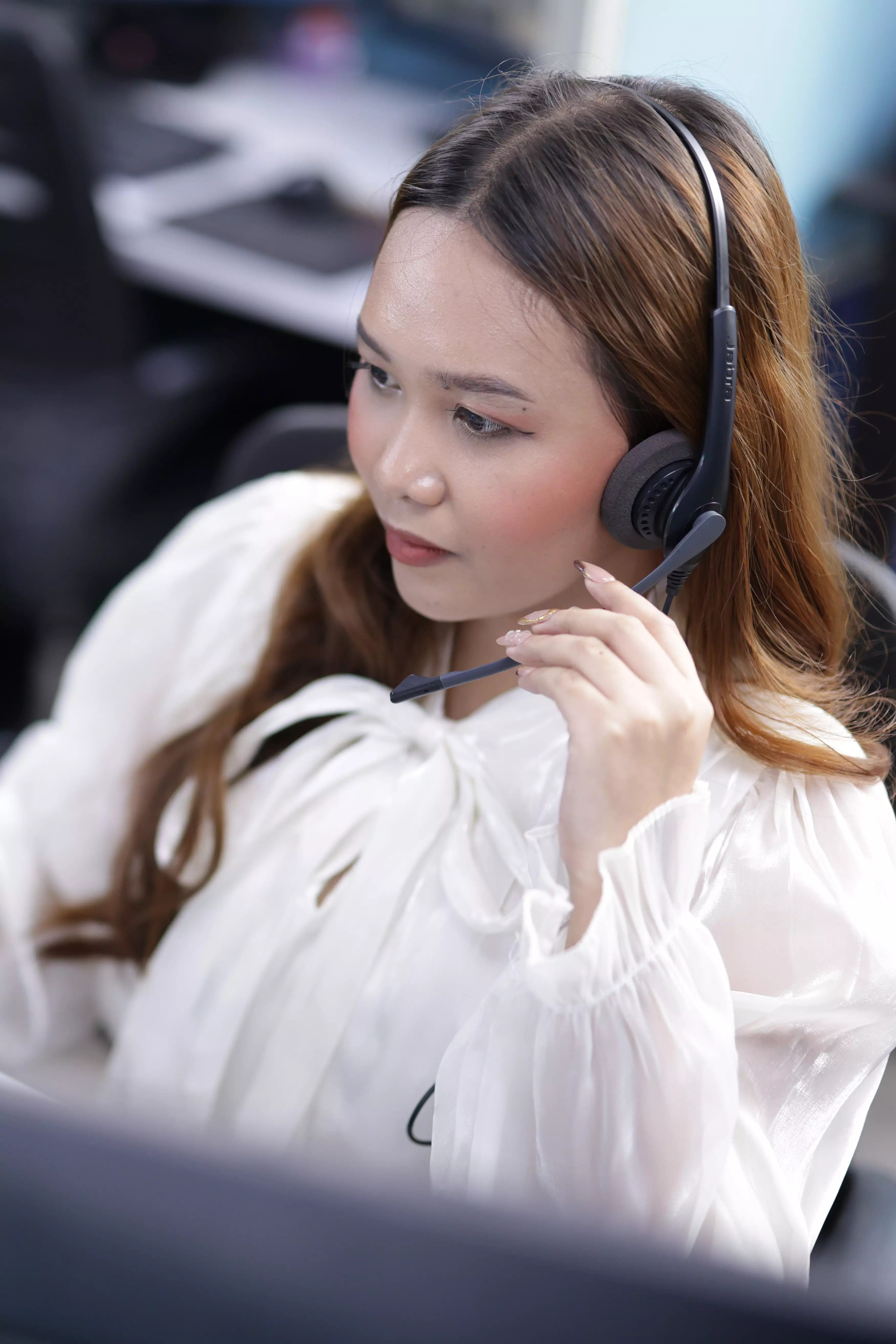 Female agent holding her mice and working at a computer workstation.